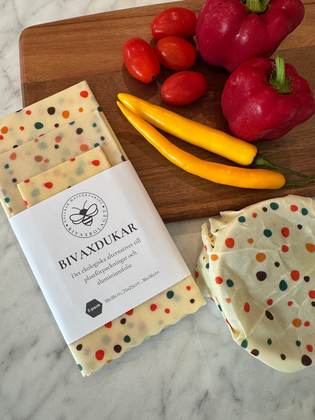 Bivaxdukar 3 pack med prickar liggandes på en bricka med grönsaker